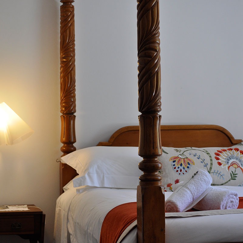 luxury Granny Goose linen and antique four poster bed in Garden View bedroom at Wildekrans Country House